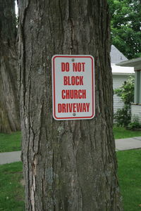 Close-up of warning sign on tree trunk