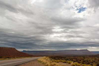 Road by landscape against sky