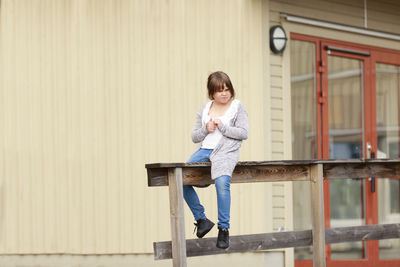 Girl sitting in front of school building