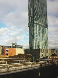 Buildings in city against cloudy sky