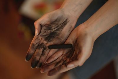 Close-up of hand holding charcoal