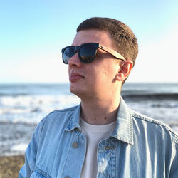 Woman wearing sunglasses standing at beach