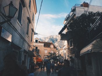 People walking in city against sky