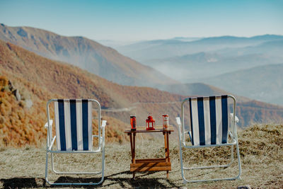 Chairs on beach against mountain range
