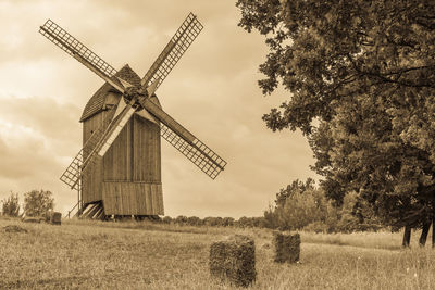 Traditional windmill on field against sky