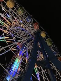 Low angle view of illuminated ferris wheel against sky at night