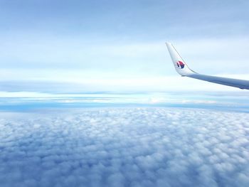 Airplane flying over sea against sky