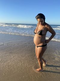 Full length of young woman standing on beach