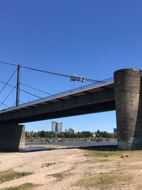 Low angle view of bridge against clear blue sky