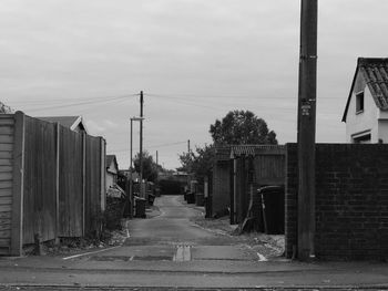 Road amidst buildings against sky