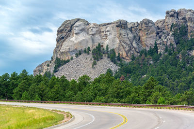 Country road by mt rushmore national monument against sky