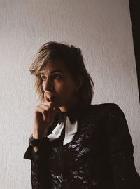 Portrait of beautiful young woman against wall at home