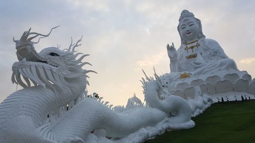 Low angle view of statues against sky