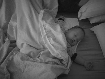 High angle view of baby sleeping at bed