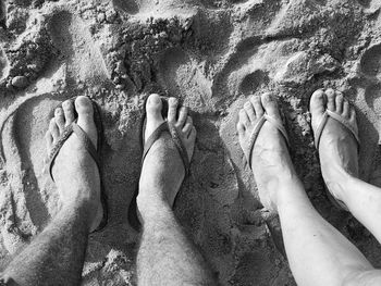 Low section of man on sand at beach