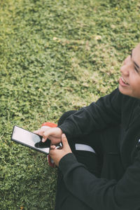 Smiling latino teenager looking at his smartphone screen
