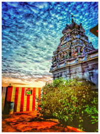 Traditional building by trees against sky