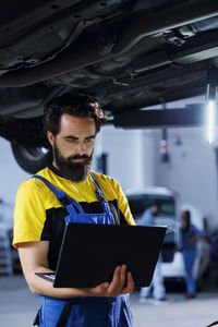 Side view of man using digital tablet at office