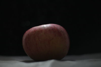 Close-up of apple on table against black background
