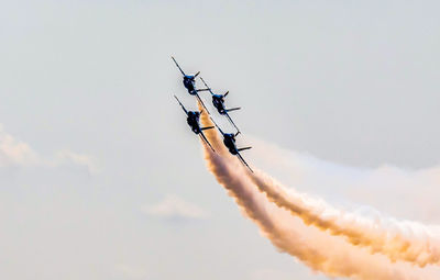 Low angle view of airshow in mid-air against sky