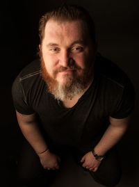 Portrait of man against black background