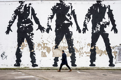 Silhouette man walking on road in city