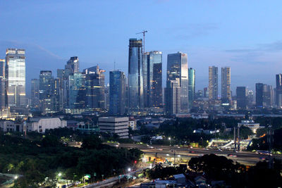 Illuminated cityscape against sky at night