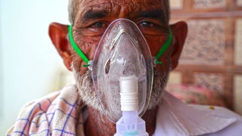 Close-up portrait of senior wearing oxygen mask