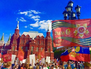 Crowd outside temple against blue sky in city