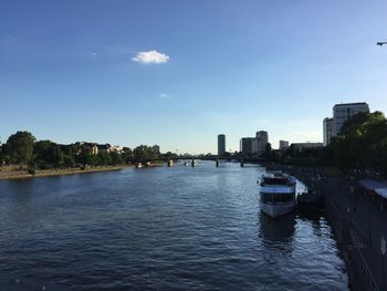 Scenic view of river by buildings against sky