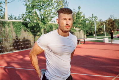 Portrait of young man standing on road