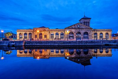 Reflection of building in lake at dusk