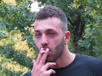 Portrait of young man smoking cigarette