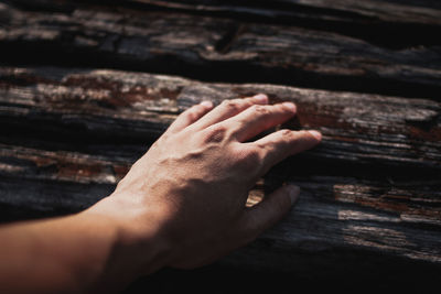 Close-up of hand touching wood