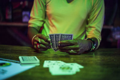 Midsection of woman playing cards