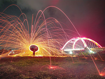 Light trails on field against sky at night