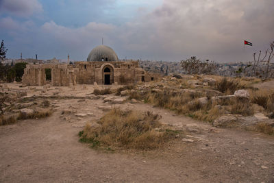 Castle on field against cloudy sky