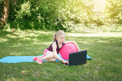 Woman sitting on chair in grass