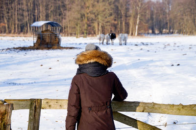 Rear view of man standing in snow