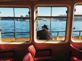 Rear view of man sitting in ferry boat