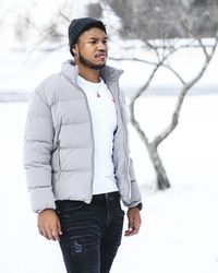 Young man standing on snow covered field