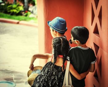 Rear view of siblings standing outdoors