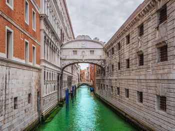 Bridge over canal amidst buildings in city