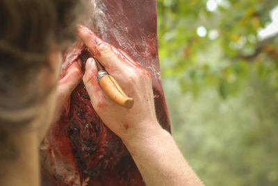 Cropped image of man cutting meat