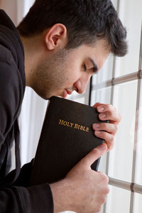 Close-up portrait of young man holding text