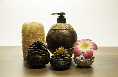 Close-up of various flowers on table against wall