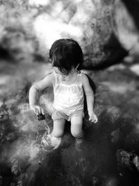 Rear view of girl playing in water
