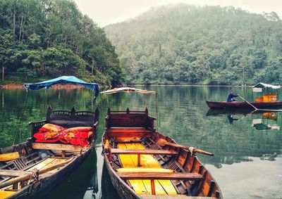 Man boating on lake against mountains