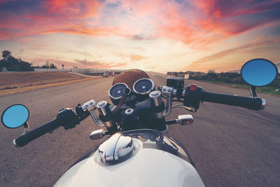 Motorcycle on road against sky during sunset