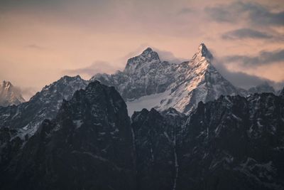 Scenic view of snowcapped mountains against sky during sunset